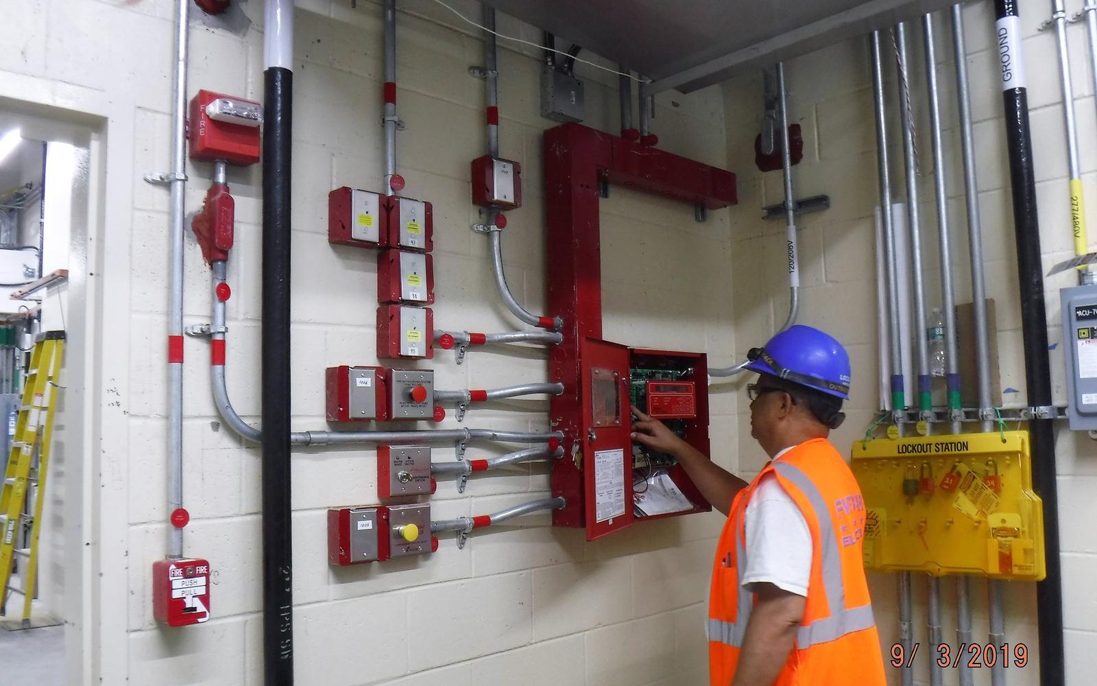 Technicien contrôlant une installation de sécurité incendie